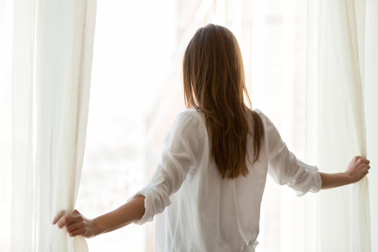 girl opening the curtain